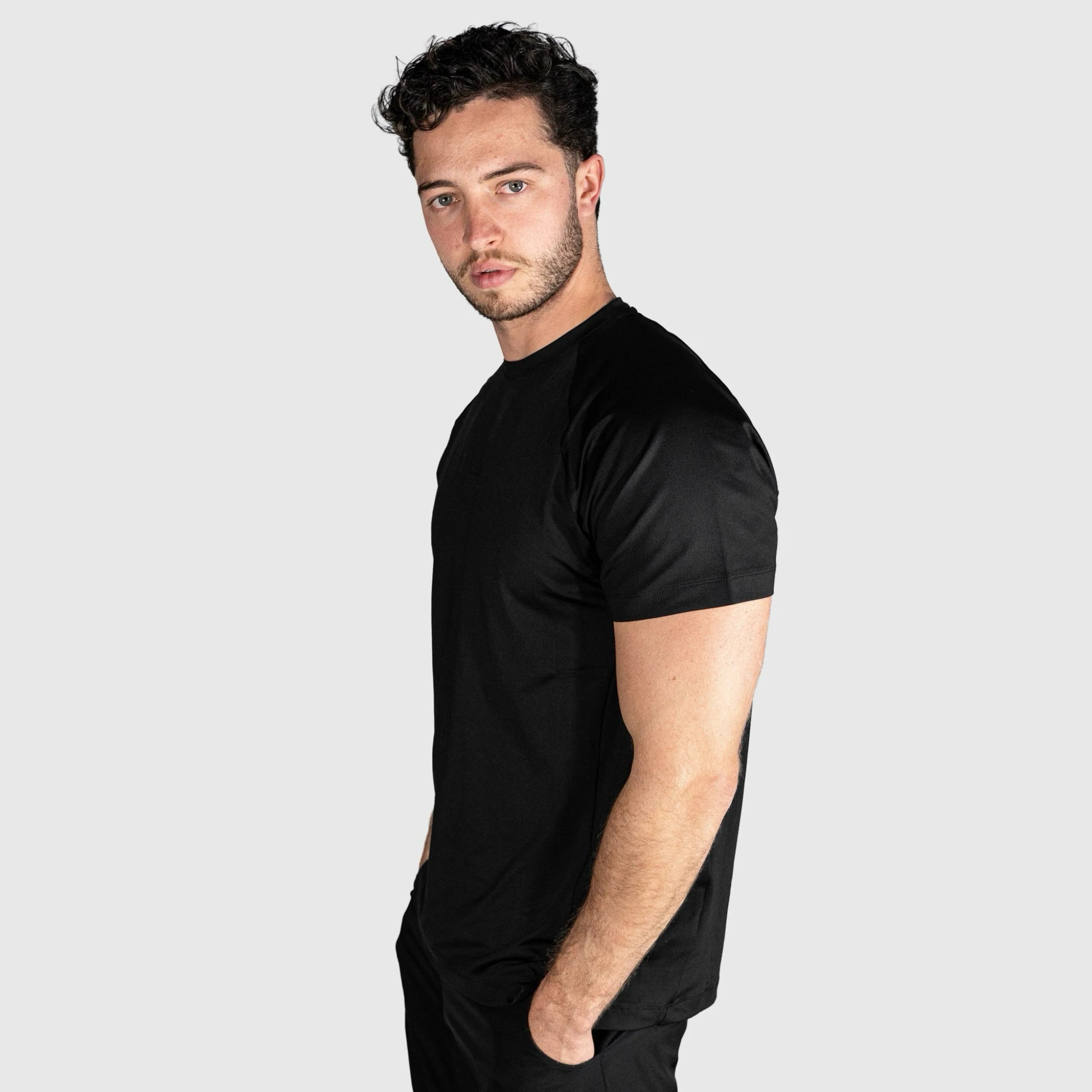Man wearing a QUAD Ace Padel T shirt against a light grey background