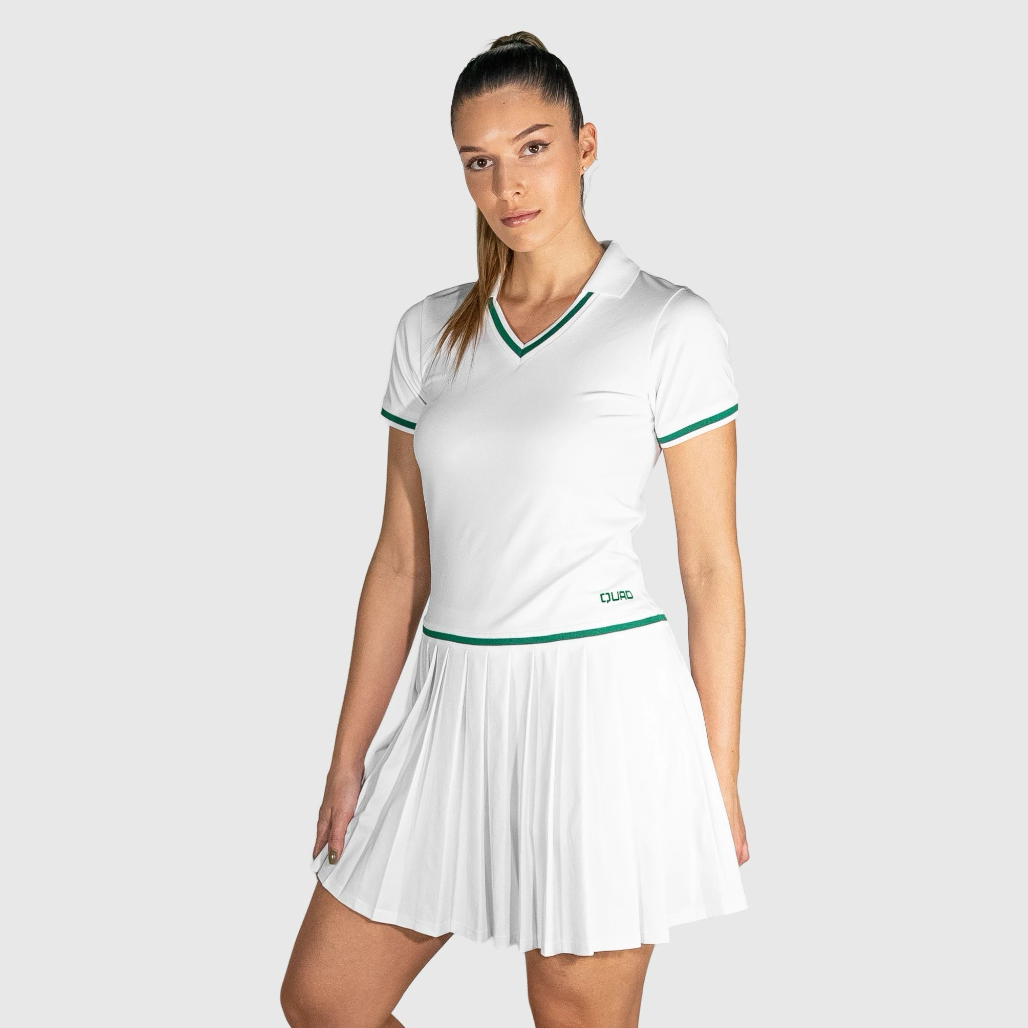 Woman wearing a QUAD Court Padel Dress with green accents on a light gray background