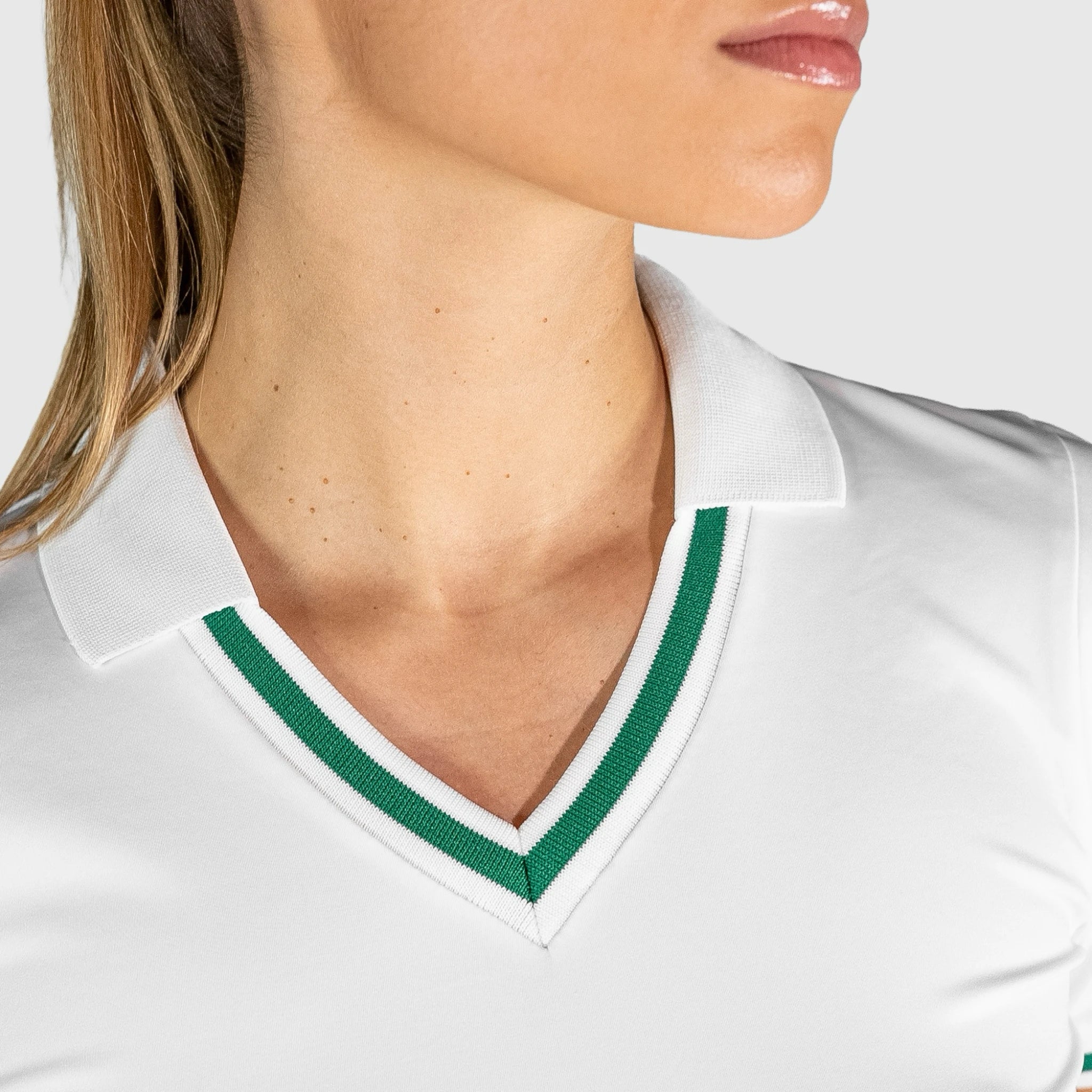 Close-up of QUAD Court Padel Dress with green trim worn by a person.