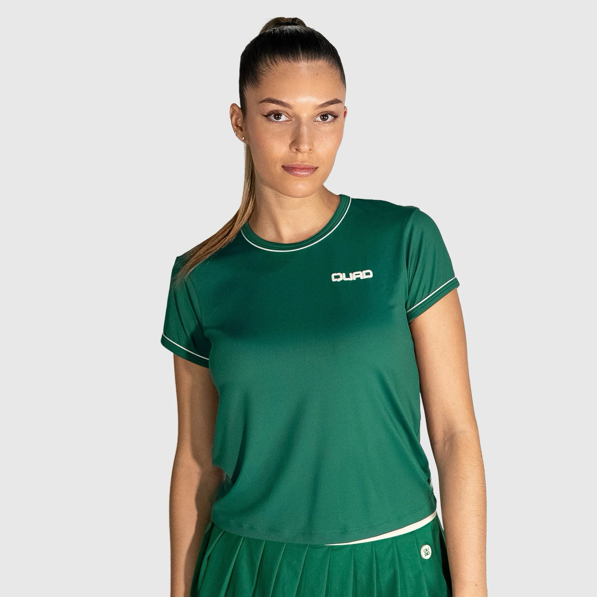 Woman wearing a New Regular Padel shirt with a visible brand logo on a light gray background