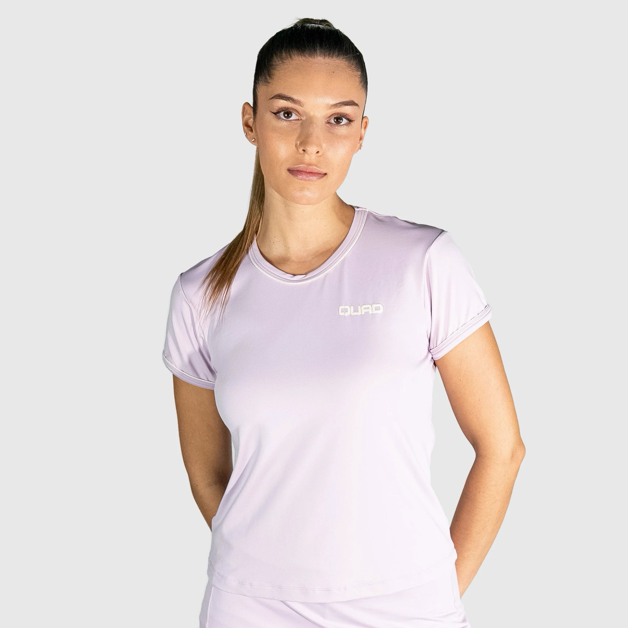 Woman wearing a New Regular Padel shirt with a brand logo on a white background