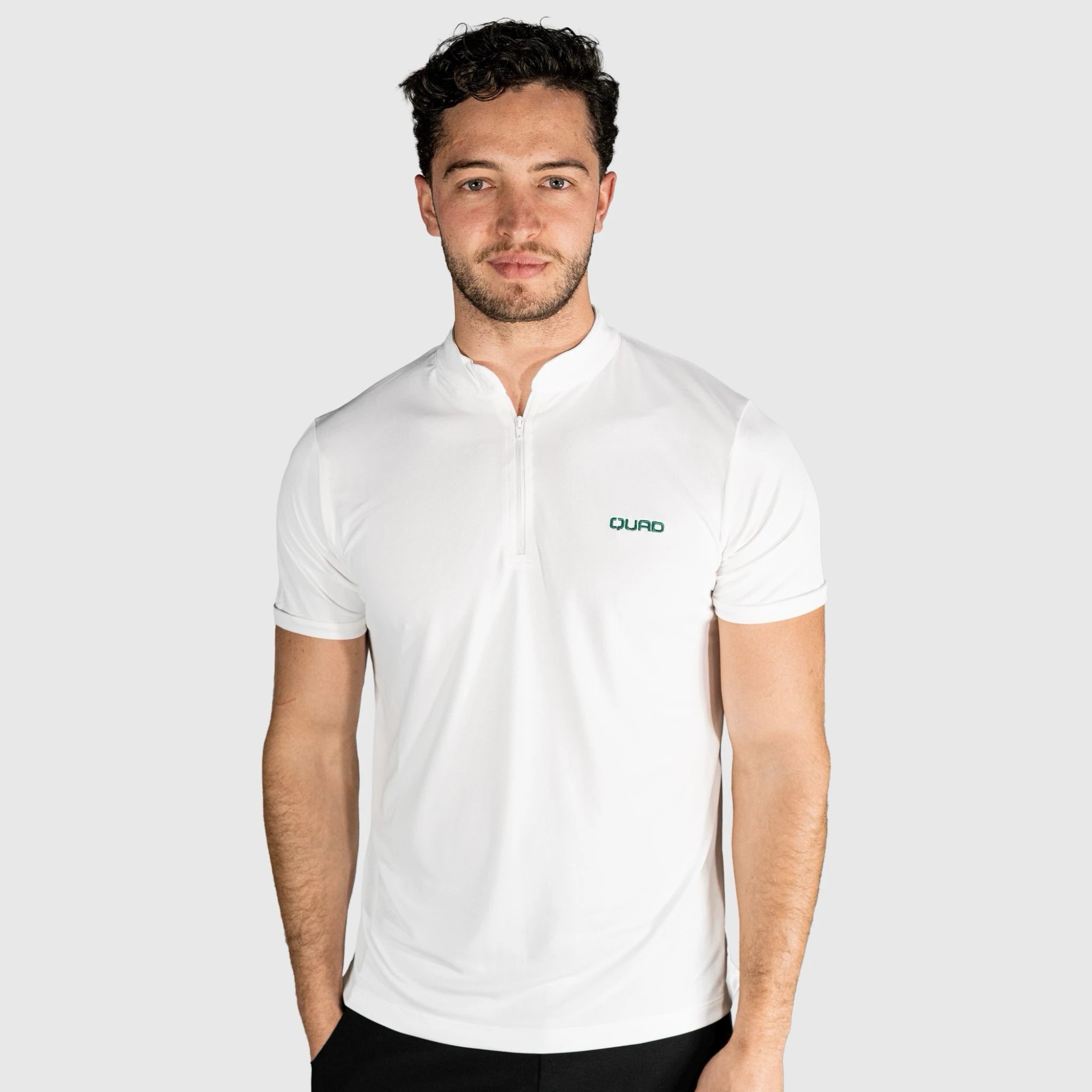 Man wearing a QUAD Padel Polo White with a brand logo on a light grey background