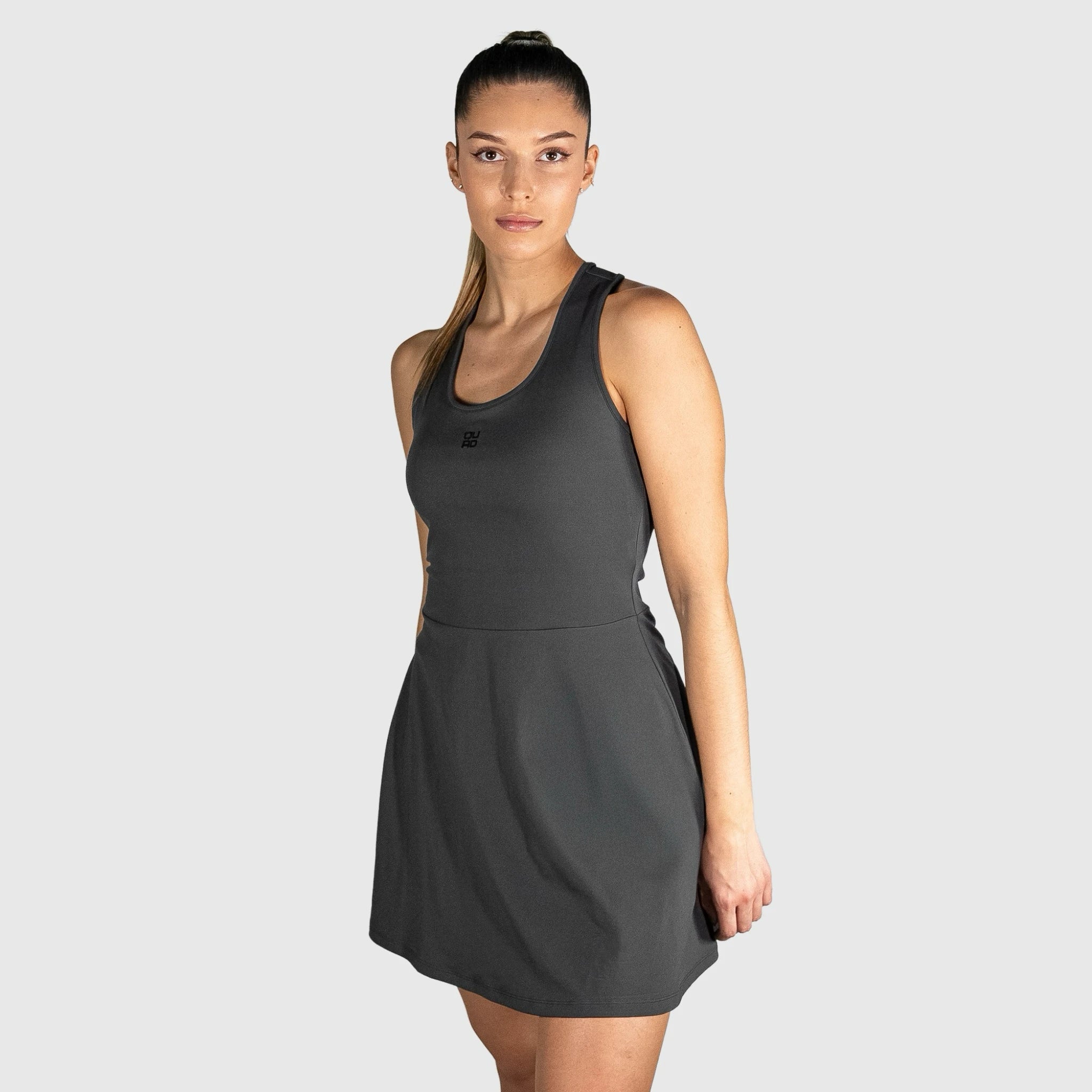 Woman wearing a QUAD Twist Padel Dress against a light grey background