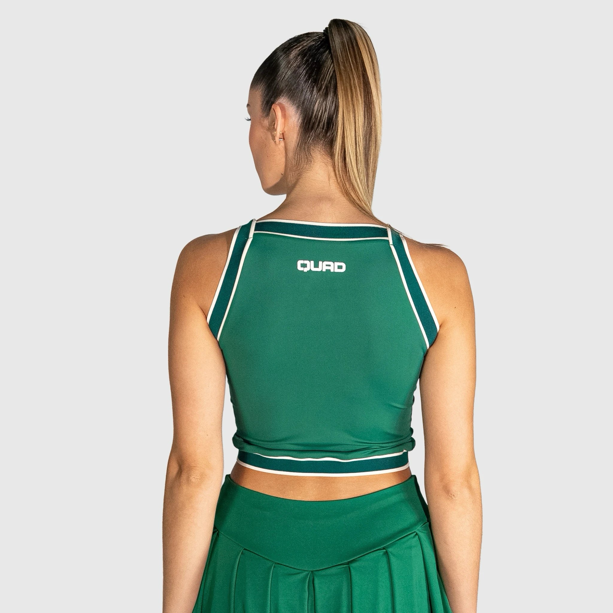 Person wearing a slice padel top with 'QUAD' branding on a light grey background