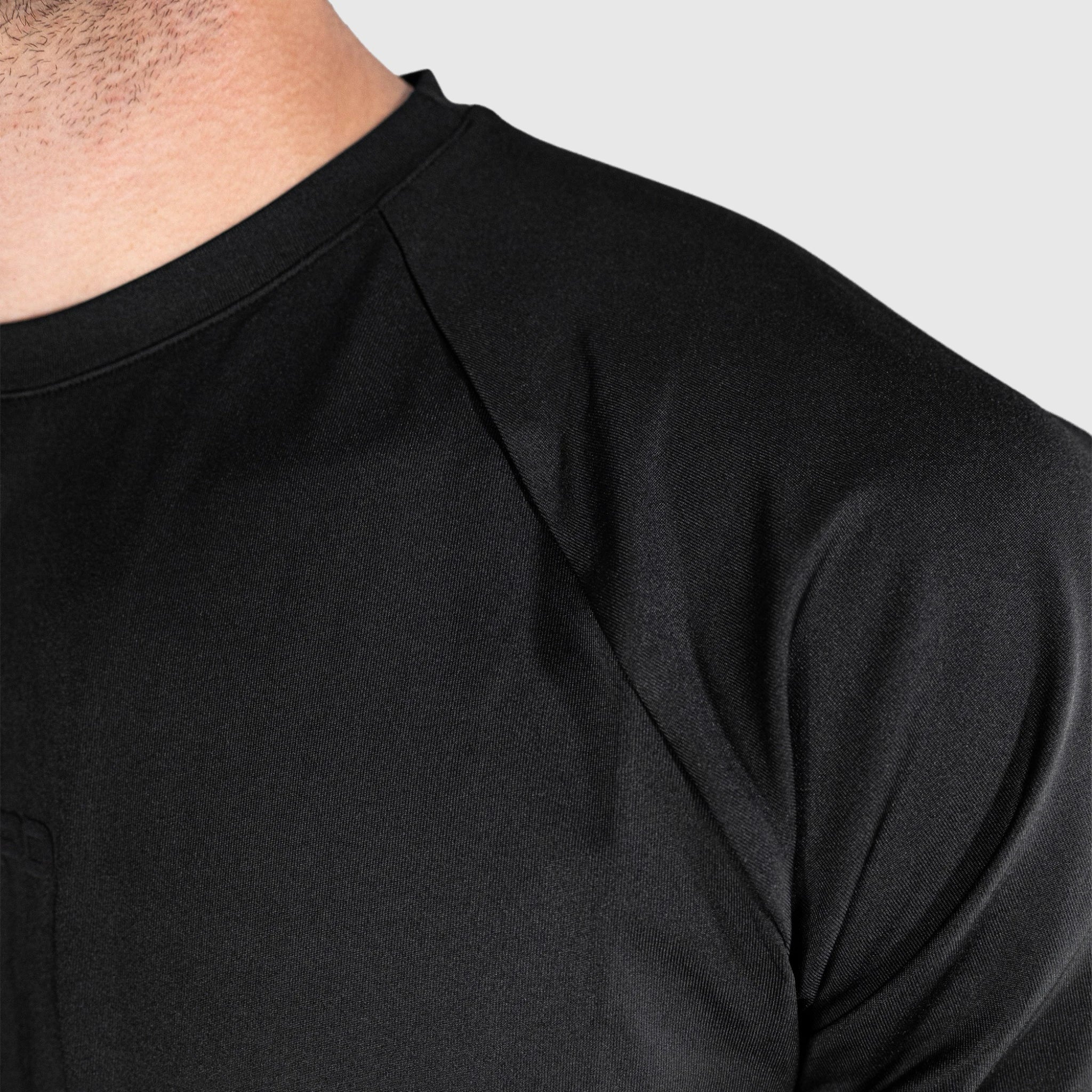 Close-up of a person wearing a QUAD Ace Padel T shirt against a grey background