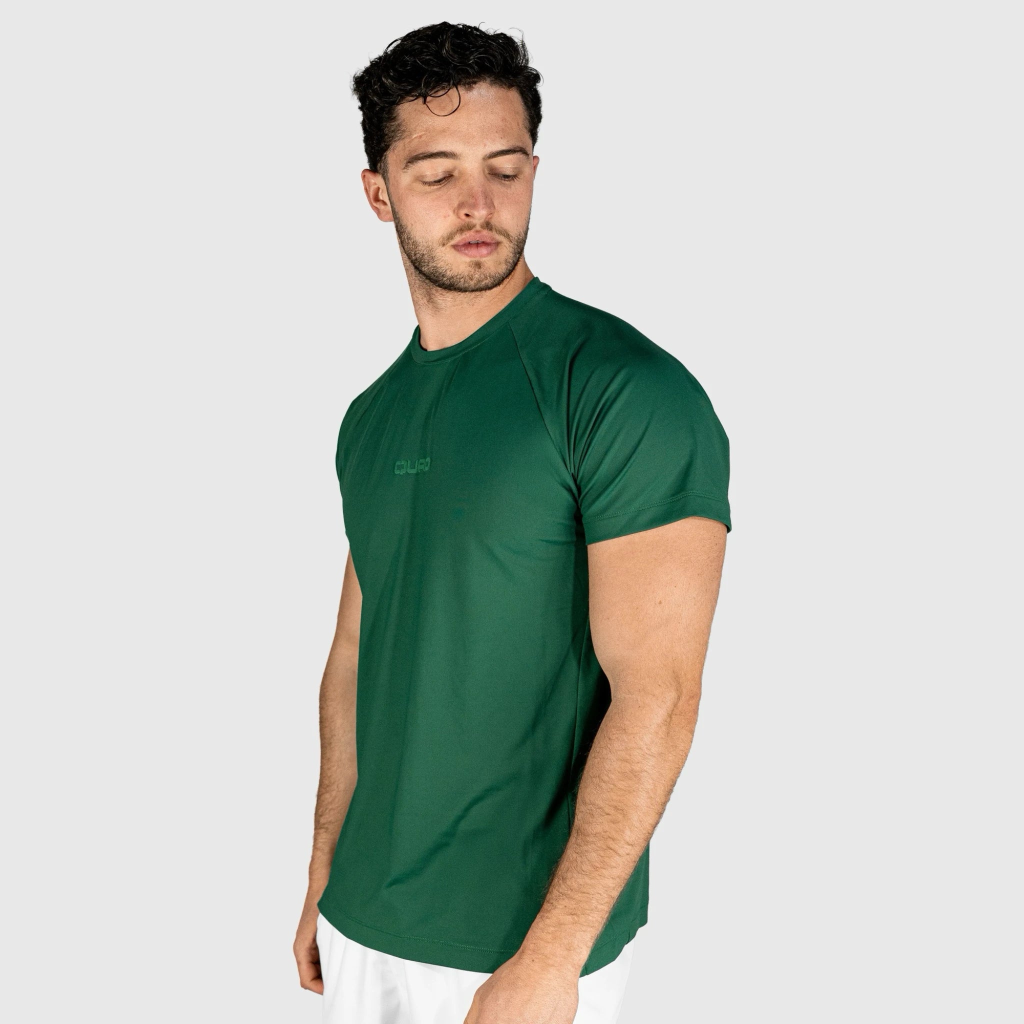 Man wearing a QUAD Ace Padel green T-shirt on a plain background