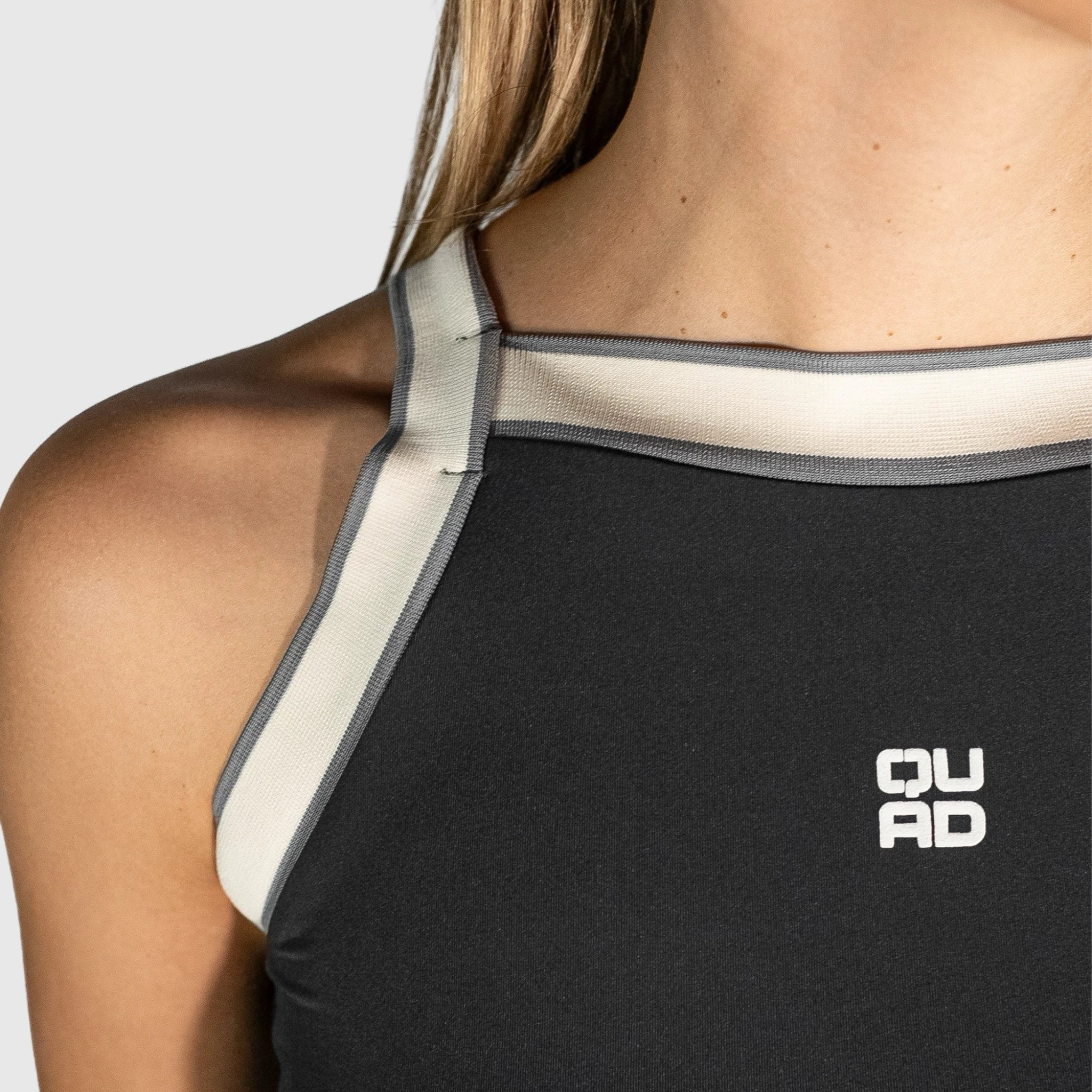 QUAD Aim Padel Top  with white trim and 'QUAD' logo on a neutral background