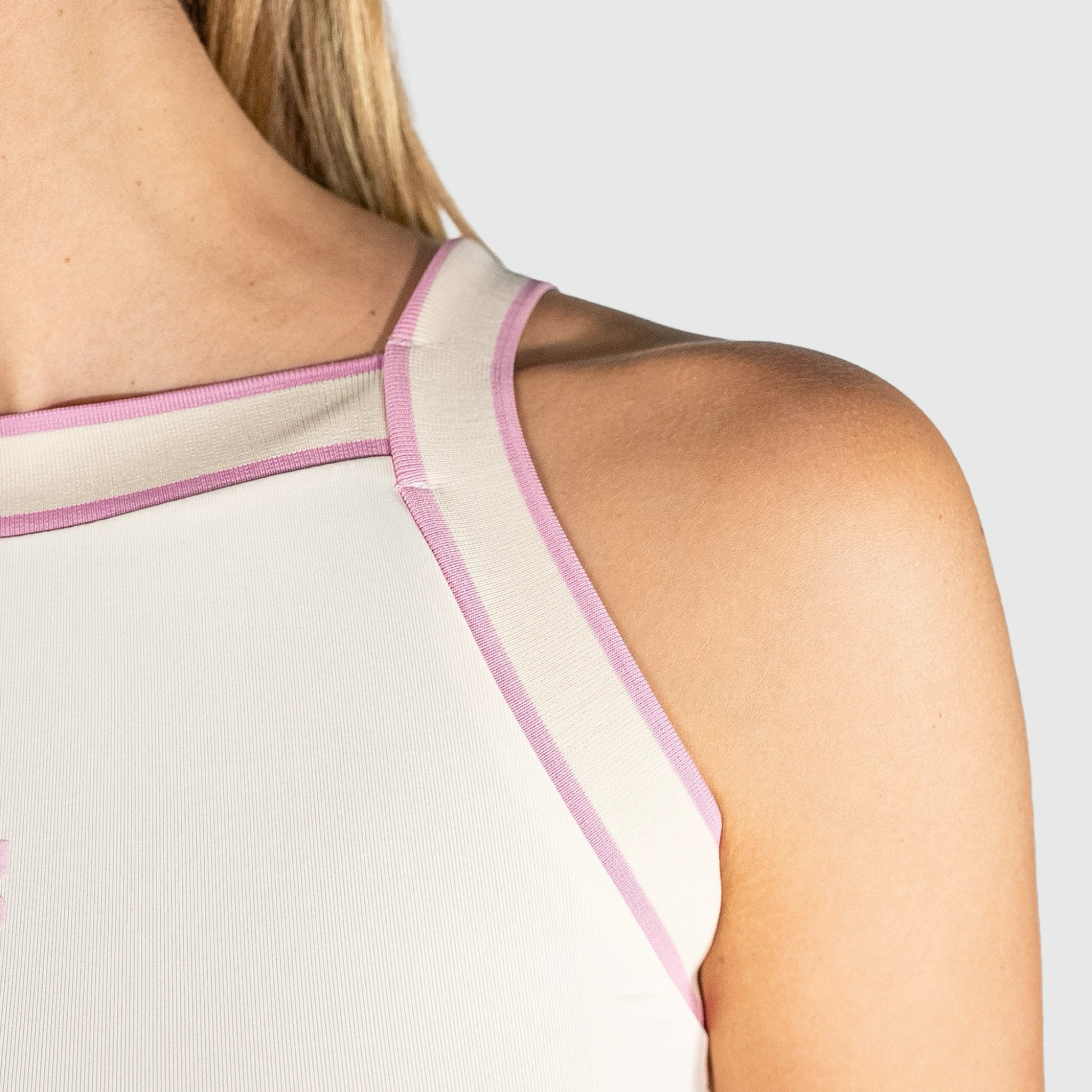Close-up of a person slice padel top tank top with pink straps on a light grey background
